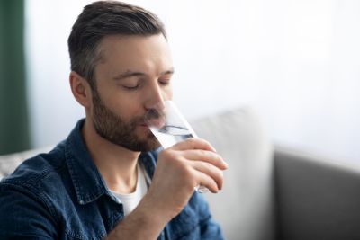 Мужчина пьет чистую питьевую воду